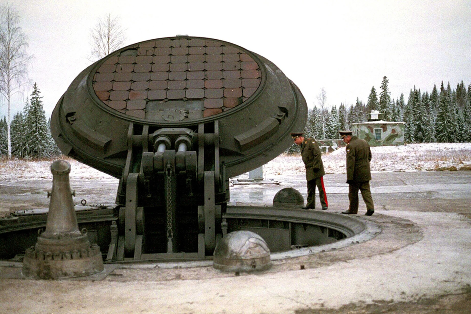 Russian military officials peer into an opened silo of an intercontinental ballistic Topol-M missile at an undisclosed location.