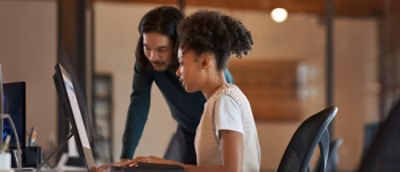 A man and woman looking at a computer.