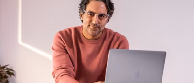 Person using laptop while seated indoors