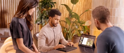 A man sitting at a desk using a laptop.