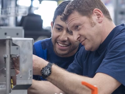 A close-up of two people looking at a metal object.