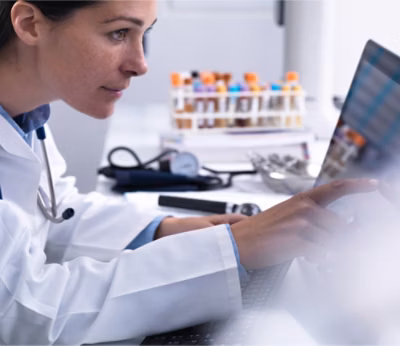 A Doctor in a white coat using a computer