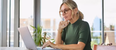 A woman using a laptop in an office.