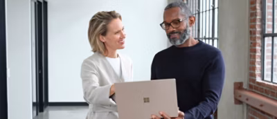A man and woman looking at a laptop