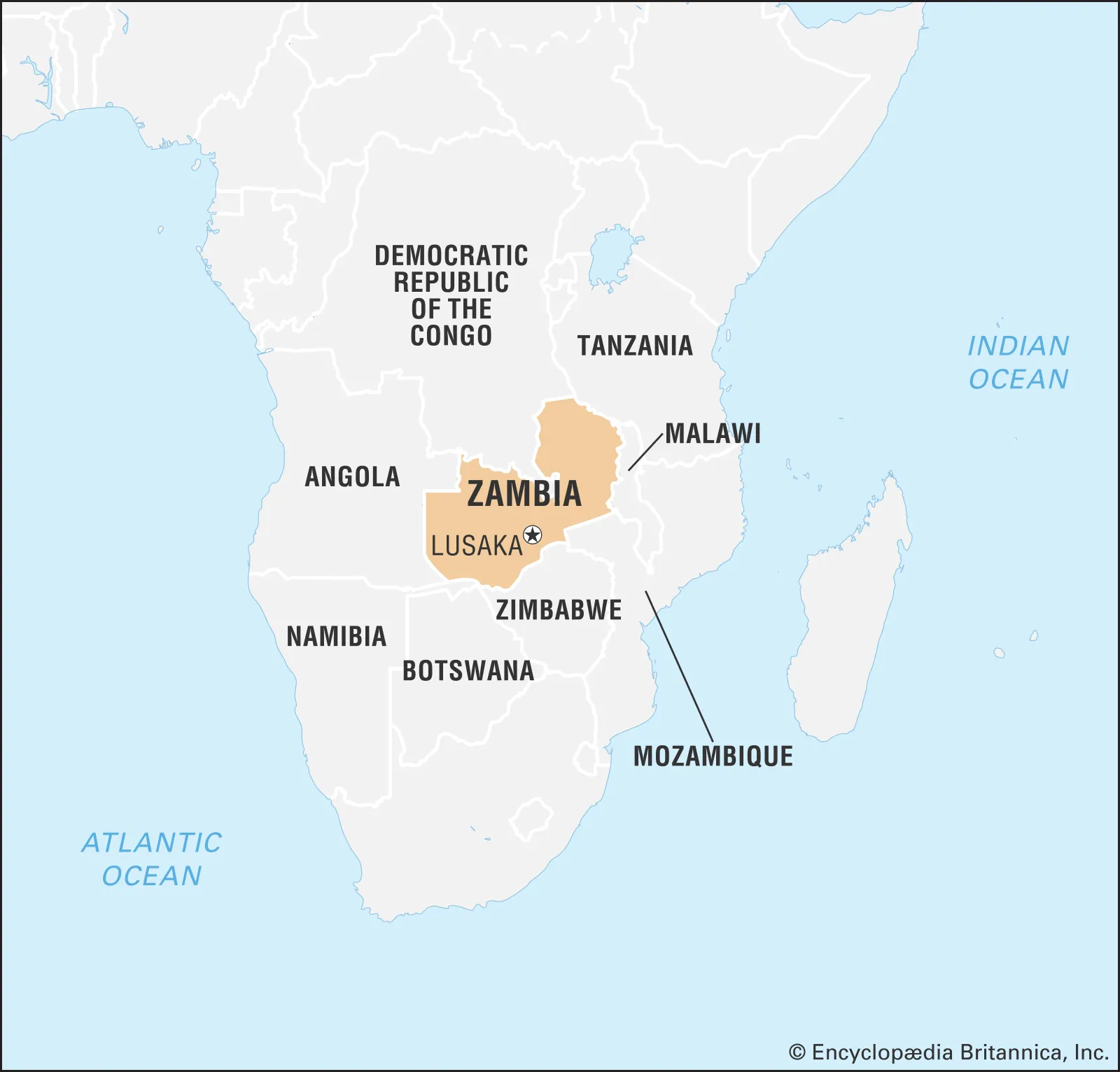 Map of southern Africa highlighting Zambia in tan, with its capital Lusaka marked. Neighboring countries including the Democratic Republic of the Congo, Tanzania, Malawi, Mozambique, Zimbabwe, Botswana, and Angola are labeled in black. Surrounding oceans are also shown.