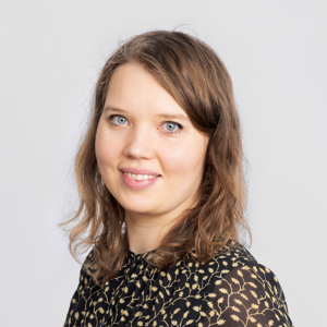 Kristiina Silvan. Brown hair, green shirt with white spots.