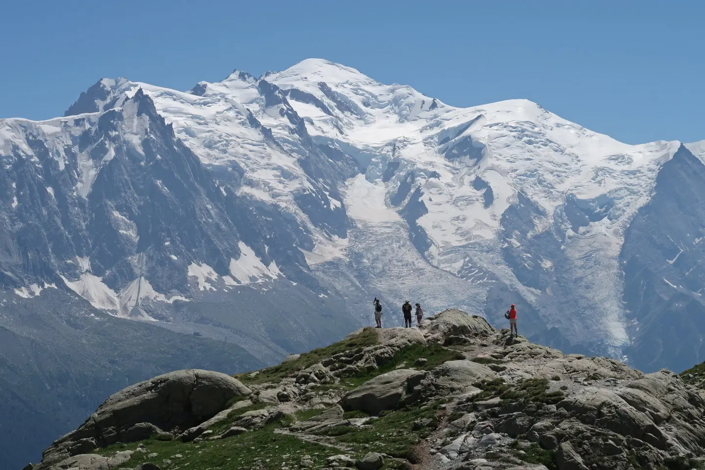 Hikers on the Tour du Mont Blanc look towards the looming Mont Blanc.