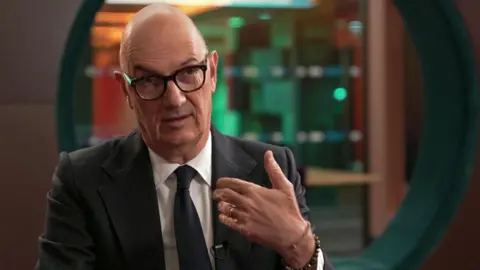 French finance minister Roland Lescure, wearing a dark suit and tie and glasses, during a BBC interview