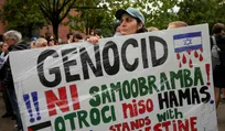 A pro-Palestine protester holds a placard reading "Genocide is not self defense, children are not Hamas, Slovenia stands with Palestine" during a rally outside the newly opened Israeli embassy in Ljubljana, Slovenia, Wednesday, Sept. 9, 2026. (AP Photo/Darko Bandic). Credit: Darko Bandic/אי־פי A pro-Palestine protester holds a placard reading "Genocide is not self defense, children are not Hamas, Slovenia stands with Palestine" during a rally outside the newly opened Israeli embassy in Ljubljana, Slovenia, Wednesday, Sept. 9, 2026. (AP Photo/Darko Bandic)