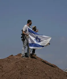 Israeli settlers on the outskirts of Beit Sahour in the West Bank on August 14. The economic repercussions of the Gaza war and surging settler violence are accelerating emigration from the West Bank. Credit: Mahmoud Illean/AP Israeli settlers on the outskirts of Beit Sahour in the West Bank on August 14. The economic repercussions of the Gaza war and surging settler violence are accelerating emigration from the West Bank.