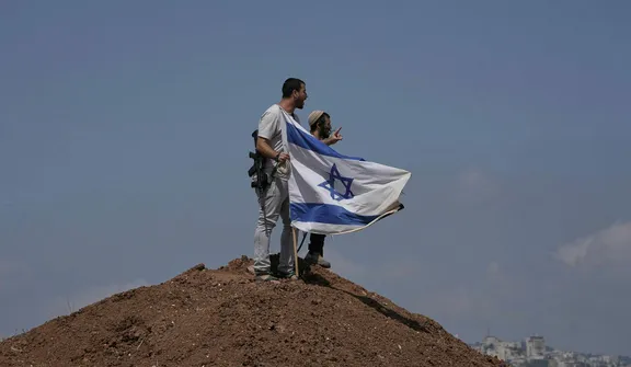 Israeli settlers on the outskirts of Beit Sahour in the West Bank on August 14. The economic repercussions of the Gaza war and surging settler violence are accelerating emigration from the West Bank. Credit: Mahmoud Illean/AP Israeli settlers on the outskirts of Beit Sahour in the West Bank on August 14. The economic repercussions of the Gaza war and surging settler violence are accelerating emigration from the West Bank.