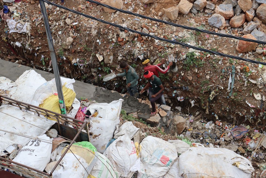 Workers build a wall near Savita's home.