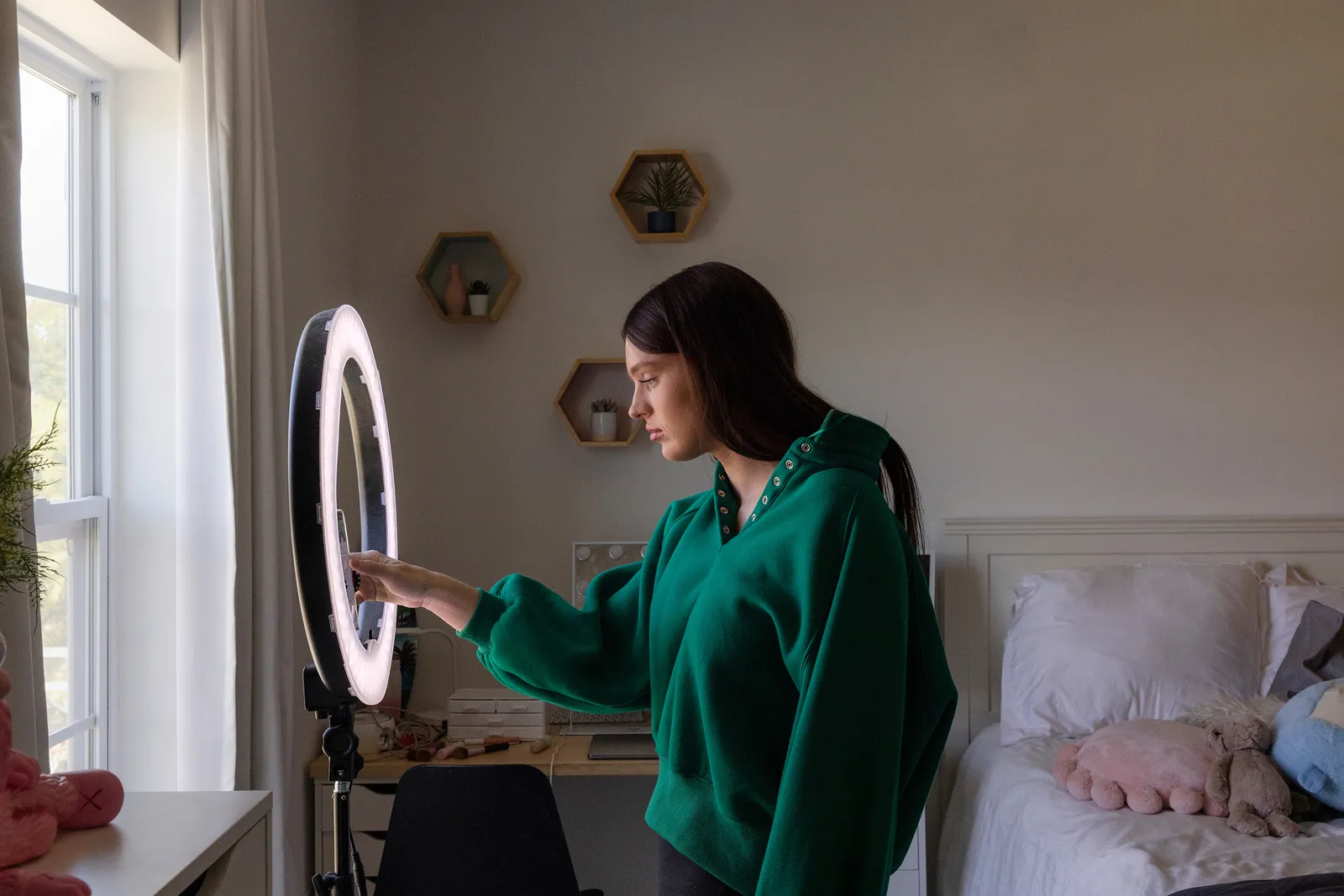 A woman looking through a ring light.