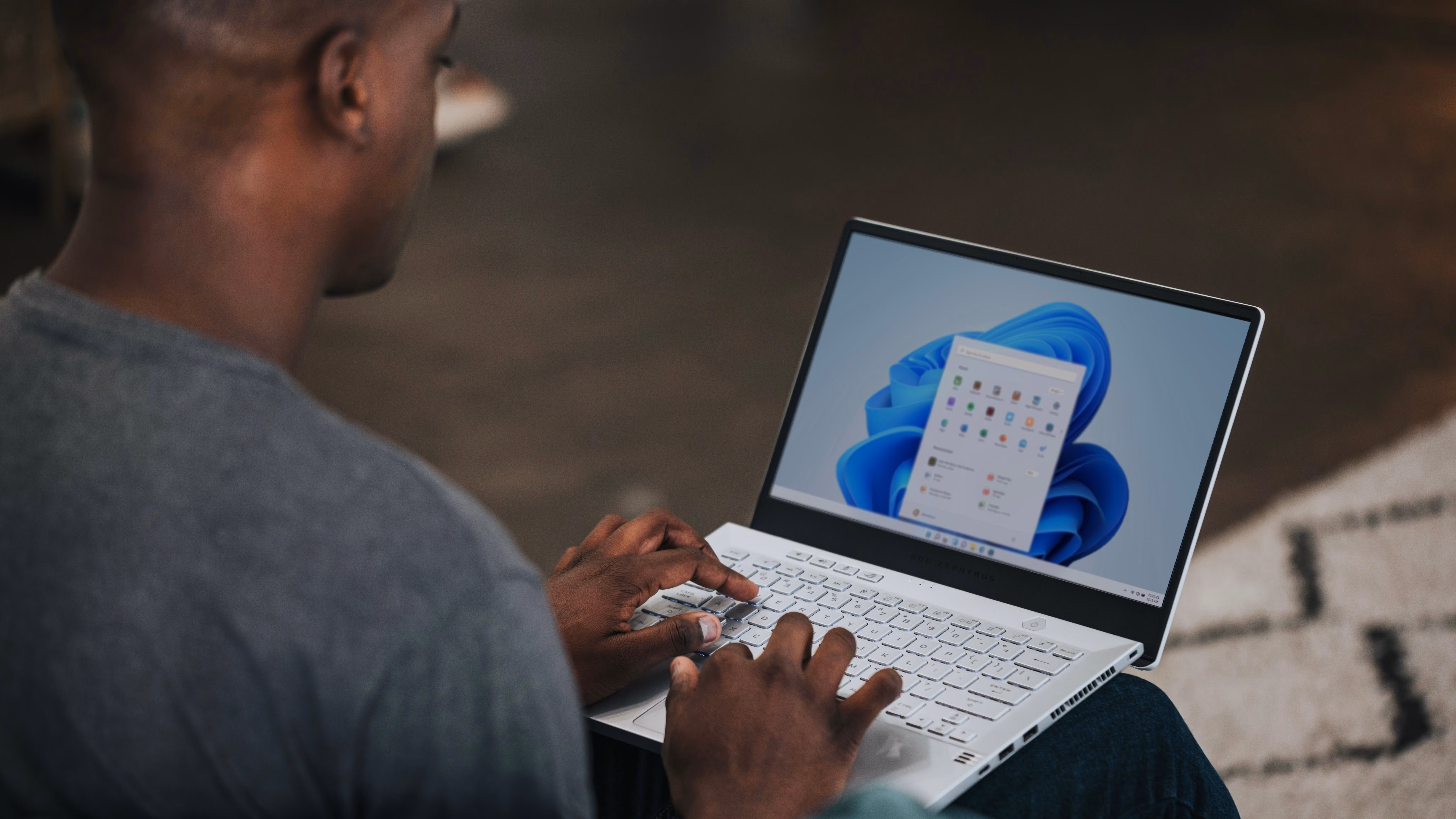 A man using a Windows 11 laptop.