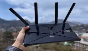 A person holding a TP-Link router