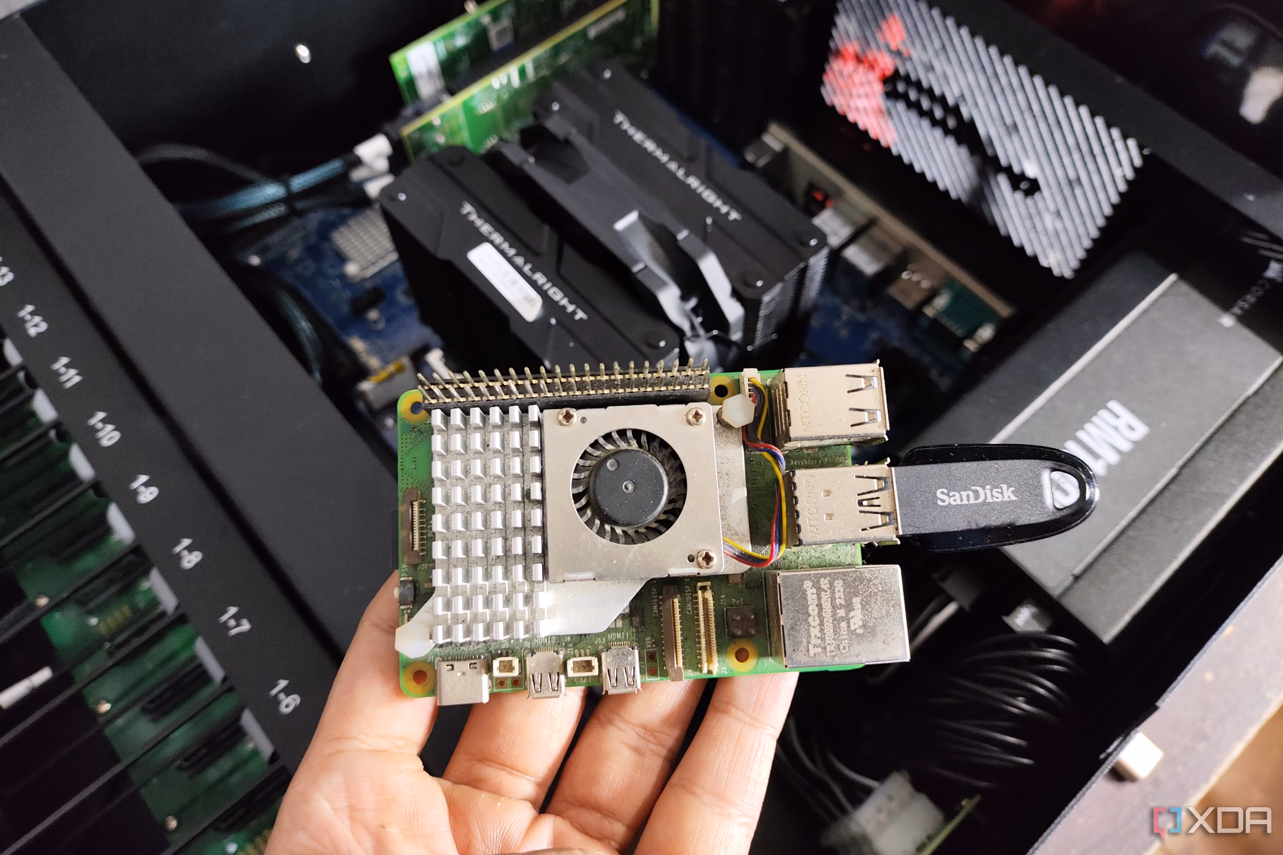 A person holding a Raspberry Pi with a USB drive connected to it