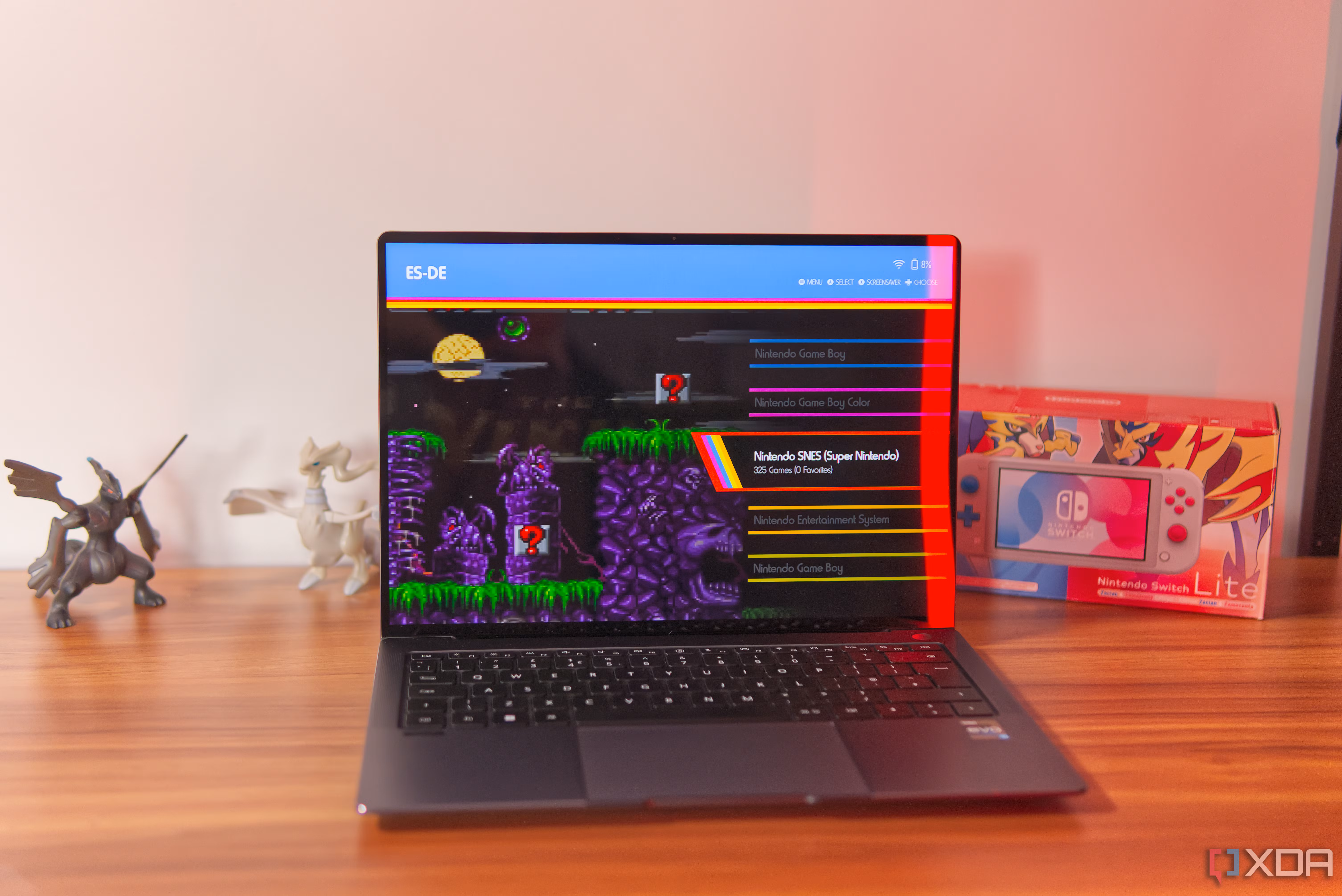 A laptop showing the library page in ES-DE, including a preview of a game for the SNES