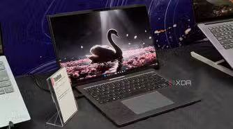 Lenovo ThinkBook Project Swan laptop on a booth table showing a swan wallpaper