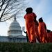 Anti-Guantanamo demonstrators dressed in Guantanamo Bay prisoner uniforms march past Capitol Hill in Washington on January 9, 2020.