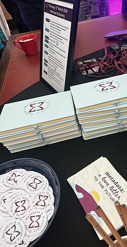 Books, stickers and postcards available on a table at a conference