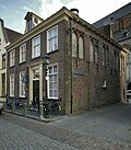 Pand met aan de achterzijde een gepleisterde gevel onder rechte lijst, dakkapel met fronton en muurankers