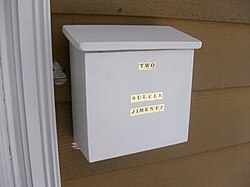 A white mailbox, attached to a wall