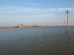 Oil wells on some raised land in the middle of a body of water