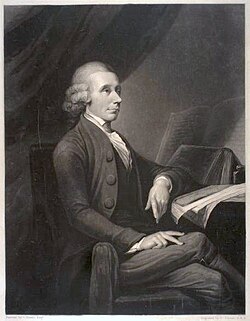 A drawing of an elderly man sitting by the table and facing parallel to the drawing. His left arm rests on a notebook, legs crossed
