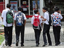 Murid sekolah berjalan di sebuah jalan di Villingili, Maldives