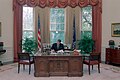 President Ronald Reagan working on the Resolute Desk in the Oval Office.