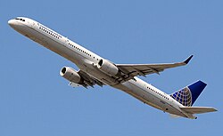 Vue du dessous d'un avion de ligne à réacteurs qui s'élève dans les airs.
