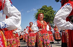 Women wearing red traditional Portuguese costumes with embroidered aprons and gold jewellery at the Romaria de Nossa Senhora da Agonia.