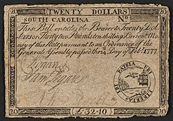 A twenty-dollar banknote issued by South Carolina in 1777 with the inscription: "SOUTH CAROLINA. This Bill intitles the Bearer to Twenty Dollars or Thirty two Pounds ten shillings Current Money of this State pursuant to an Ordinance of the General Assembly passed the 14th Day of Feb. 1777." ; Denominations stated as: "TWENTY DOLLARS" and "L32.10". ; Within emblem: "UBI LIBERTAS IBI PATRIA" ; Verso: "XX Dollars. DEATH TO COUNTERFEIT. L. 32:10:0".