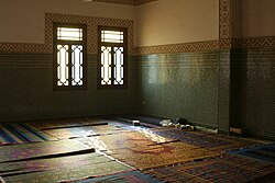 A room with a patterned wood window.