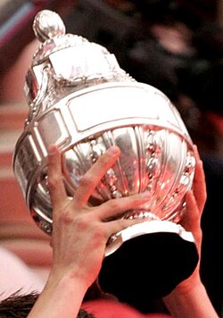 Close-up of the silver KNVB Cup trophy being held aloft.