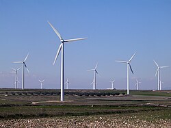 Un parc éolien composé d'une douzaine d'éoliennes blanches à trois pales.