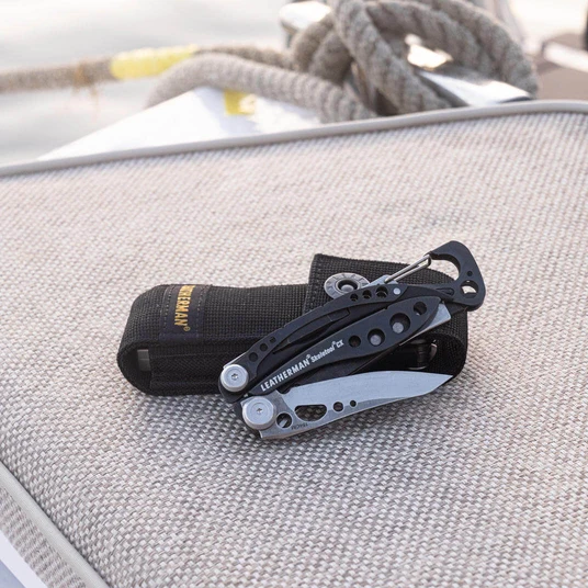 Translation missing: en.Black & stainless Leatherman Skeletool® CX with nylon sheath on a textured surface
