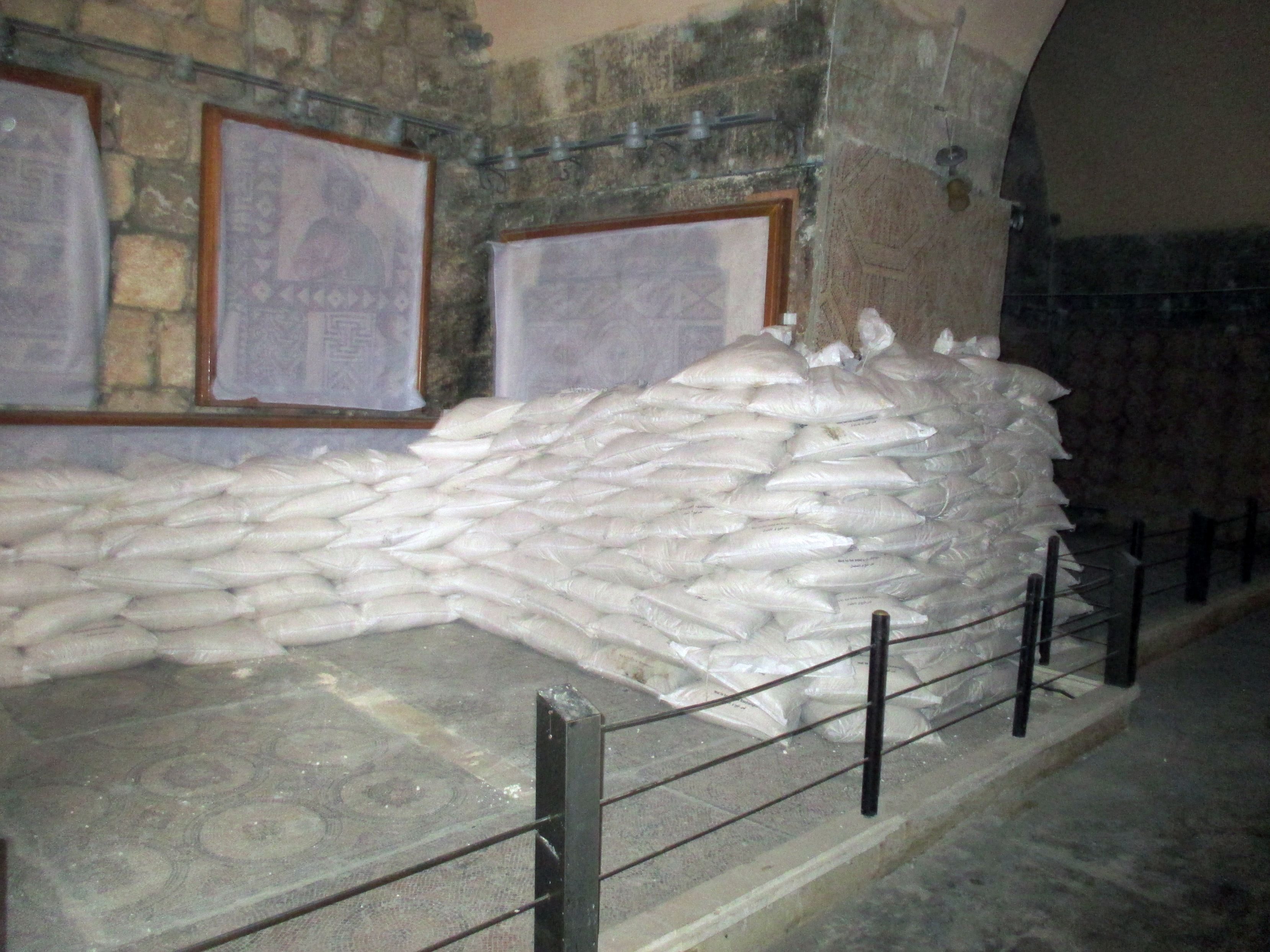 Syrian volunteers covered mosaics in the Ma’arra Museum in the Idlib province with a protective layer of glue and cloth, then several truckloads of sandbags were then laid out to protect the mosaics from damage caused by further attacks.