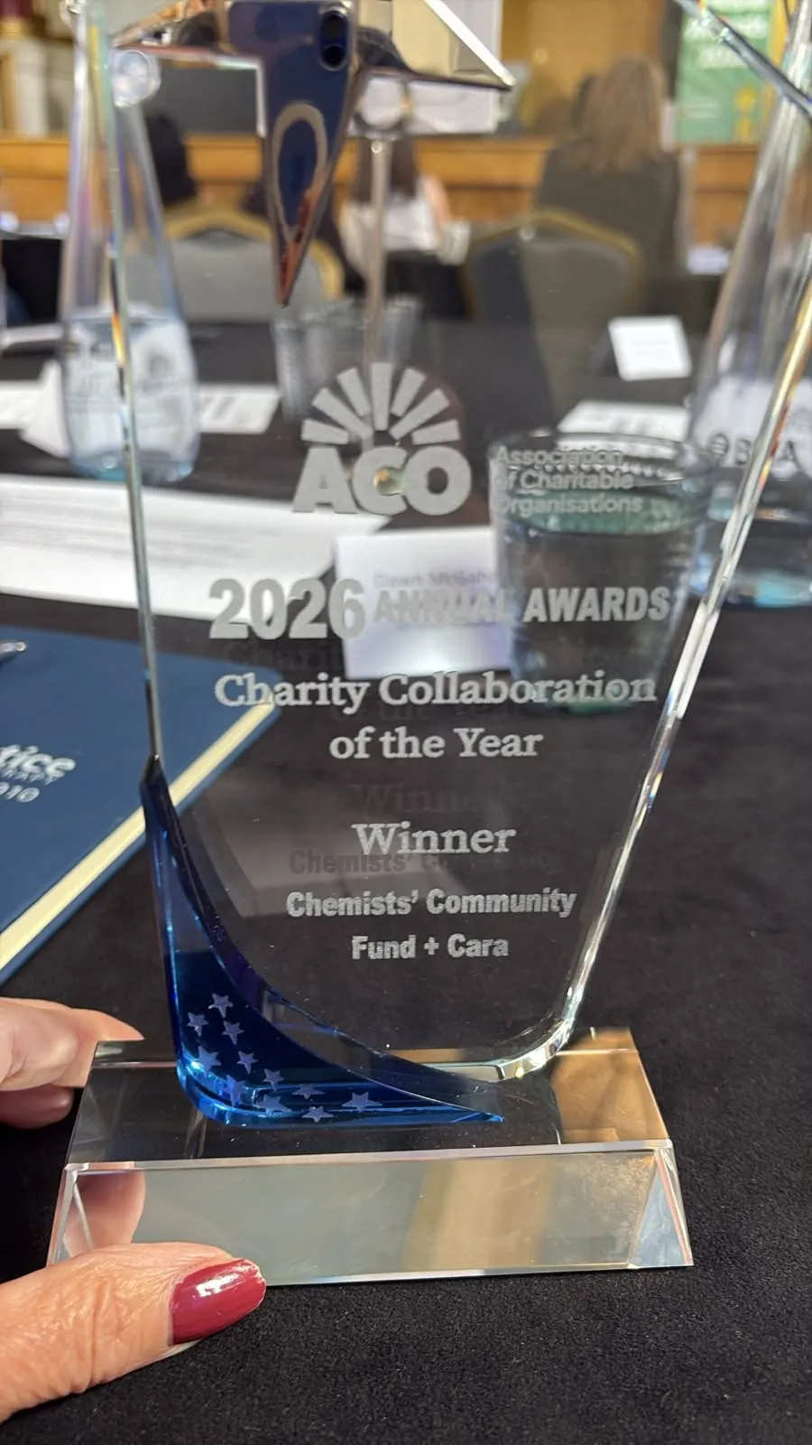 Pic of award A glass trophy that reads "ACO 2026 Annual Awards - Charity Collaboration of the Year winner: Chemists' Community Fund + Cara